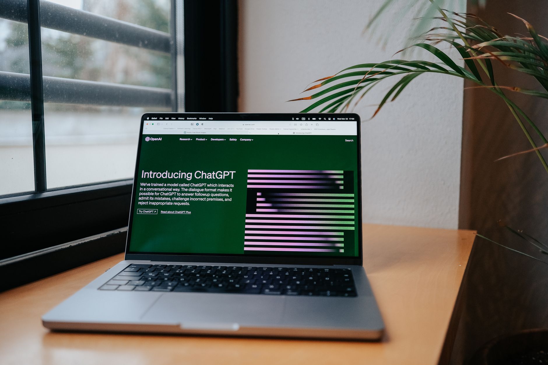 Laptop on a desk showing the OpenAI ChatGPT website