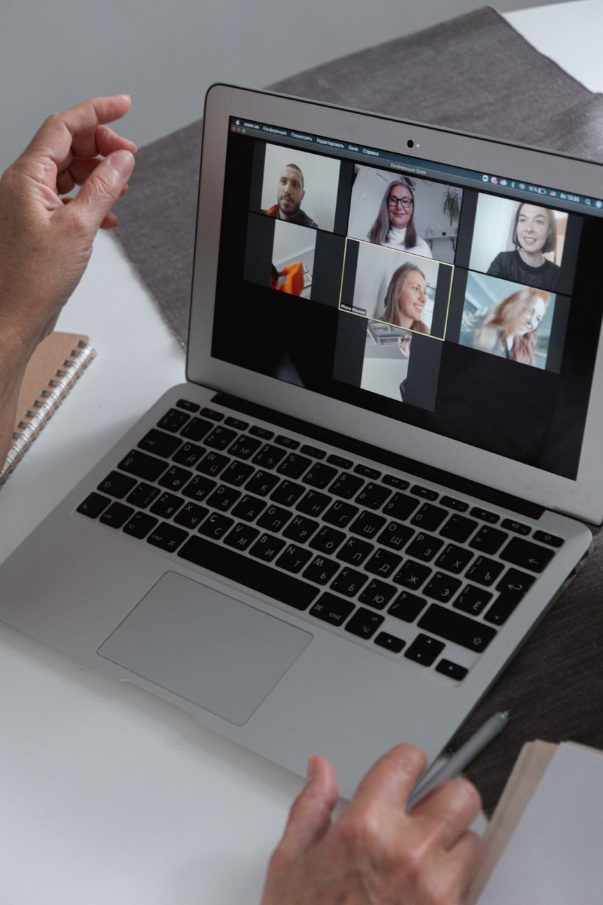 Laptop screen showing an online video meeting with an AI meeting assistant taking notes