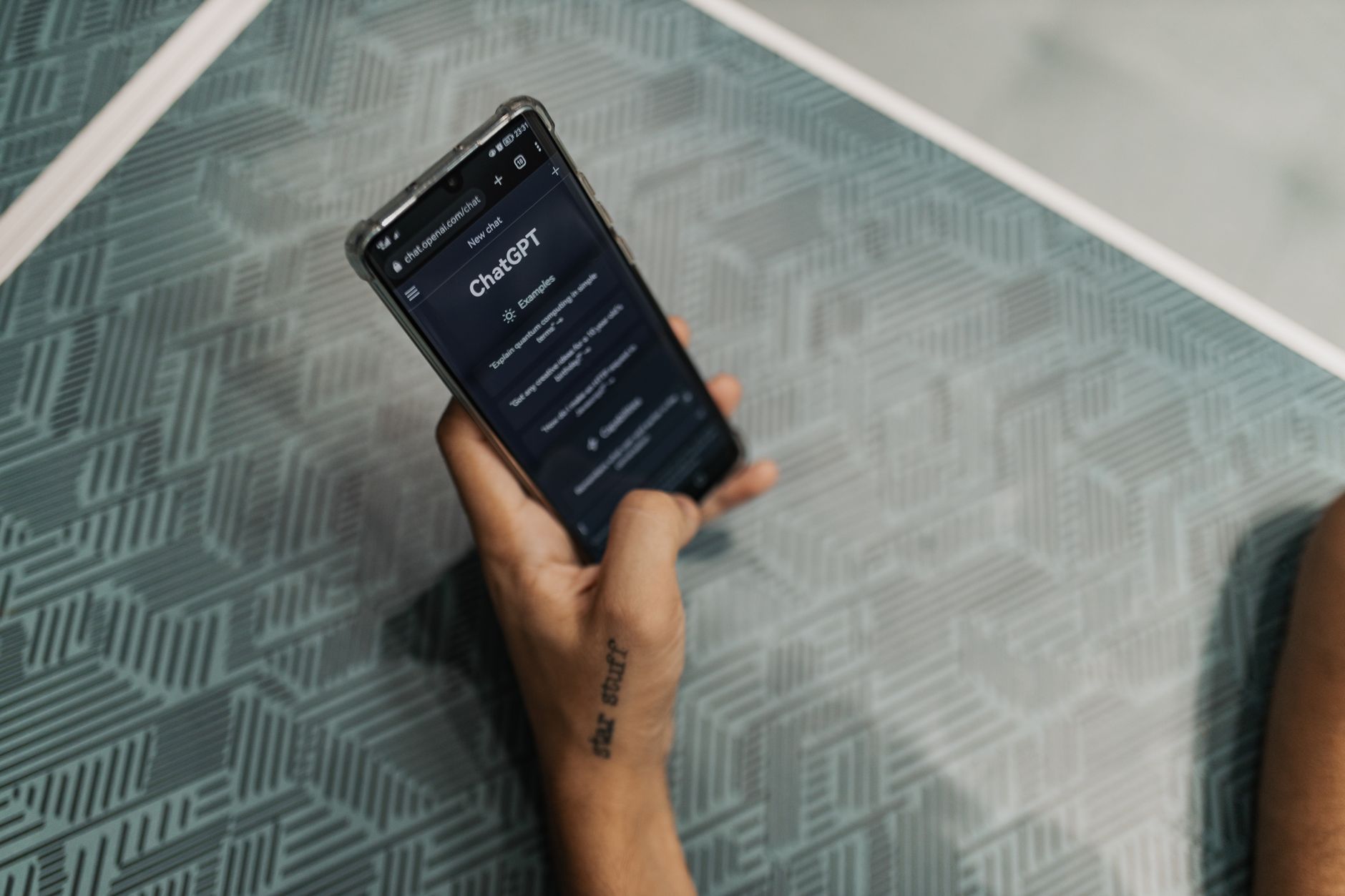 Hand holding a smartphone with the ChatGPT app open, showing the new Intelligent UI
